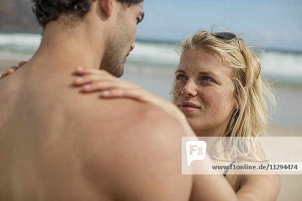 Tender young couple standing on the beach