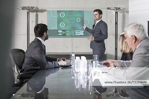 Businessman holding presentation in front of team