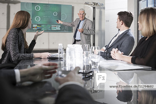 Businessman holding presentation in front of team