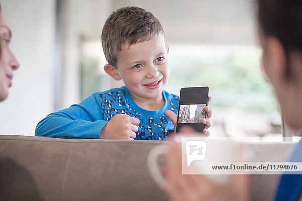 Boy holding cell phone at home