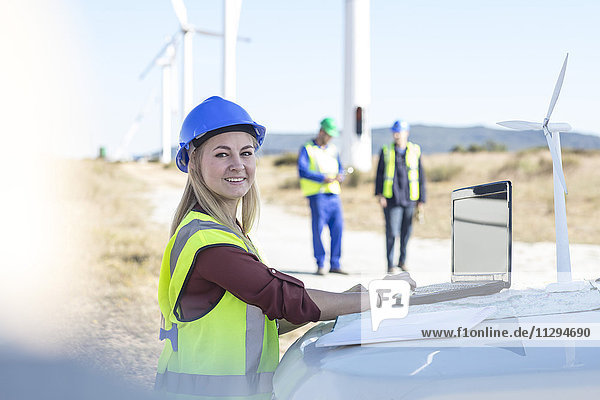 Ingenieurin bei der Arbeit im Windpark mit Laptop