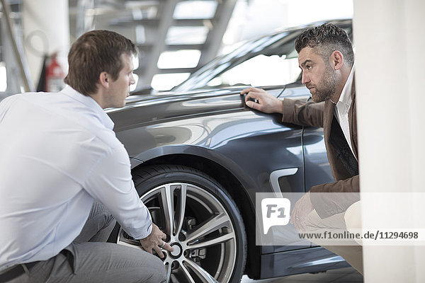 Car dealer talking to client in showroom