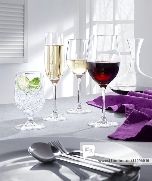 Gedeck mit gefüllten Weingläsern  Sektglas und Wasserglas  lila Serviette