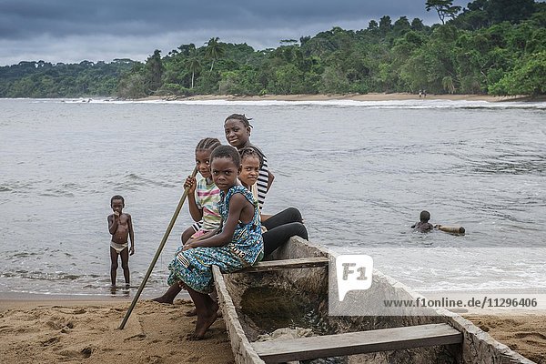 Girls  children in a dugout canoe on the beach  Ebodjé  Southern Region  Cameroon  Africa