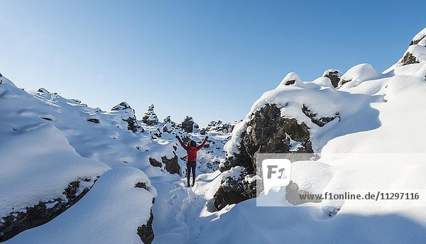 Frau mit ausgestreckten Armen  Schneelandschaft  Lavafeld bedeckt mit Schnee  Vulkansystems Krafla  Dimmuborgir Nationalpark  Mývatn  Nordisland  Island  Europa