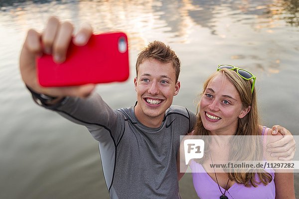 Junges Paar fotografiert sich mit einem Handy selbst  Selfie  Schliersee  Oberbayern  Bayern  Deutschland  Europa