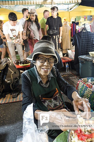 Alte Frau  Thailänderin  verkauft Blüten und Blütenketten am Nachtmarkt  Krabi Stadt  Krabi  Thailand  Asien