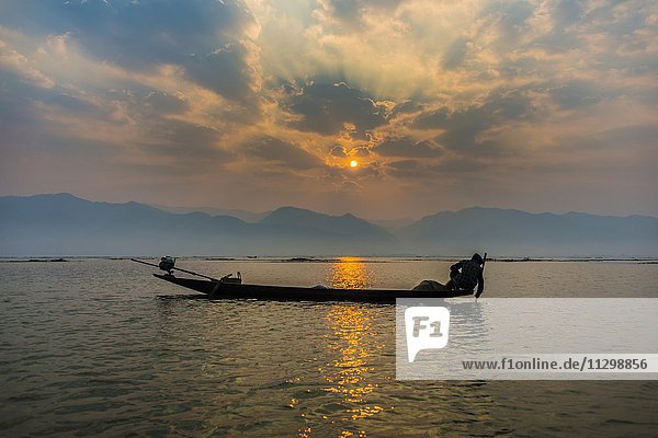 Local Intha fisherman rowing boats with one leg  unique local practice  sunrise  dawn  Inle Lake  Inle Lake  Shan State  Myanmar  Asia