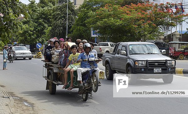 Man on scooter makes a wheelie  trailer loaded with many people  Phnom Penh  Cambodia  Asia