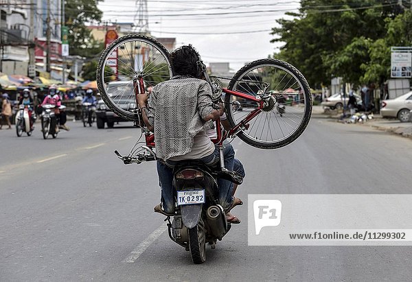 Mann mit Moped transportiert ein Fahrrad  Phnom Penh  Kambodscha  Asien