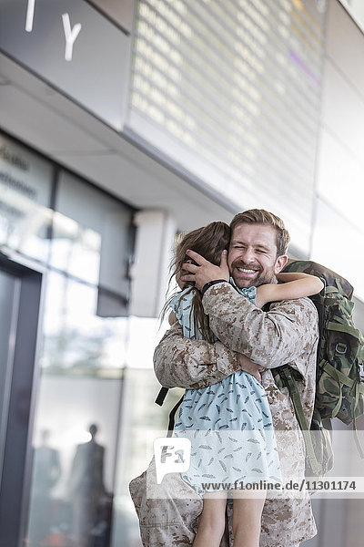 Begrüßung der Tochter und Umarmung des Soldatenvaters am Flughafen