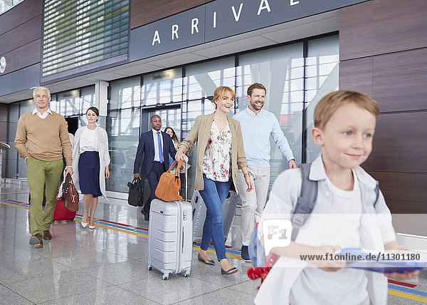 Reisende mit Koffern zu Fuß in der Flughafenhalle