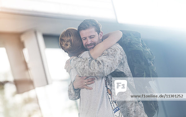 Begrüßung der Frau und Umarmung des Soldaten-Ehemannes am Flughafen