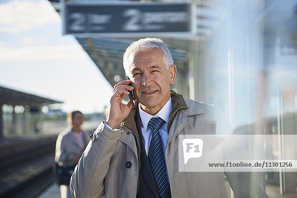 Geschäftsmann beim Telefonieren außerhalb des Flughafens