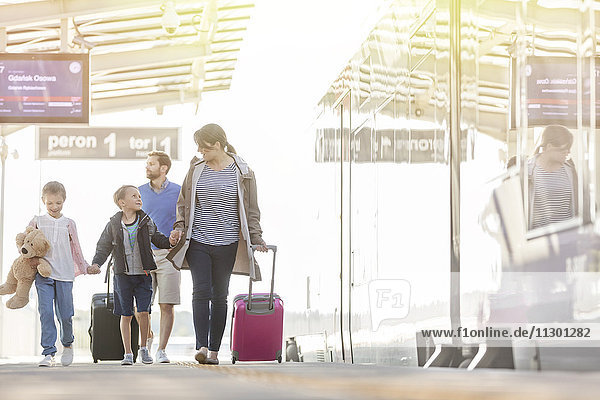 Familienspaziergang mit Koffern in der Flughafenhalle