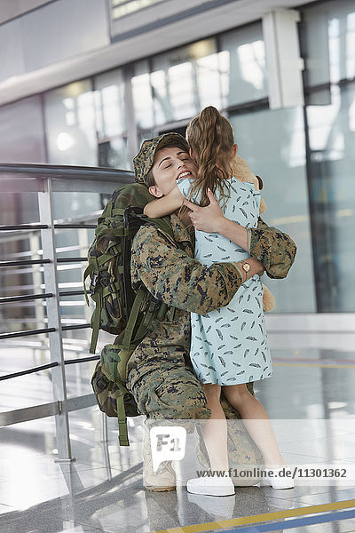 Töchtergruß umarmende Soldatenmutter am Flughafen