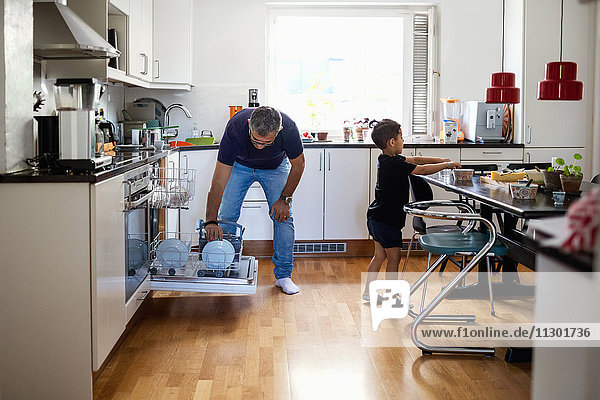 Father and son working in kitchen at home