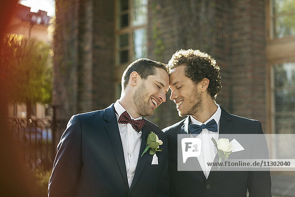 Glückliches frisch verheiratetes schwules Paar  das im Freien steht