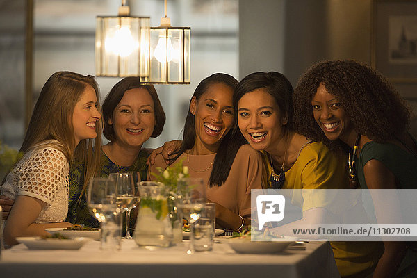 Portrait lächelnde Freundinnen beim Essen am Restauranttisch