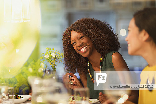 Frauenfreunde beim Lachen und Essen am Restauranttisch