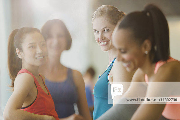 Smiling women talking in sunny gym studio