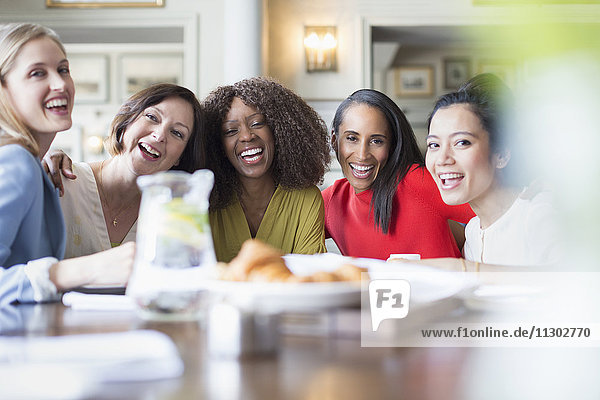 Portrait lachende Frauen Freunde beim Essen am Restauranttisch