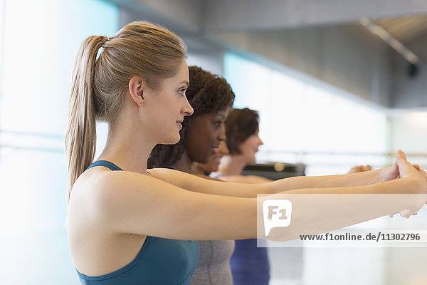 Frauen  die ihre Arme im Fitnessstudio ausstrecken