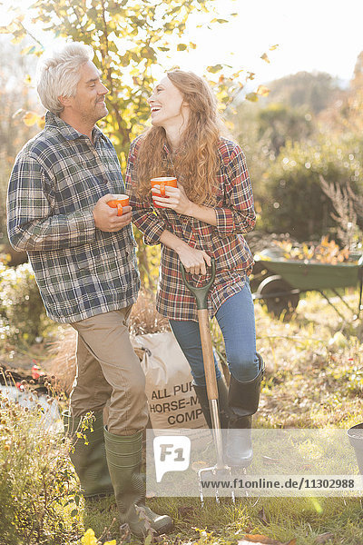 Paar lachend genießen Kaffeepause Gartenarbeit sonnigen Herbst Garten