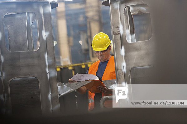 Steel worker reviewing paperwork in factory