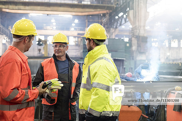 Stahlarbeiter im Gespräch in der Fabrik
