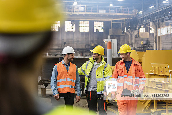 Stahlarbeiter beim Gehen und Reden in der Fabrik