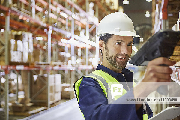 Worker using scanner in distribution warehouse