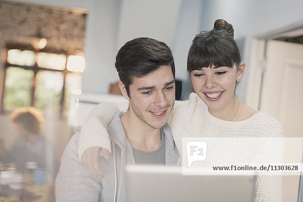Lächelndes junges Paar  das ein digitales Tablet benutzt