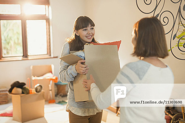 Mother helping young adult daughter moving into new apartment