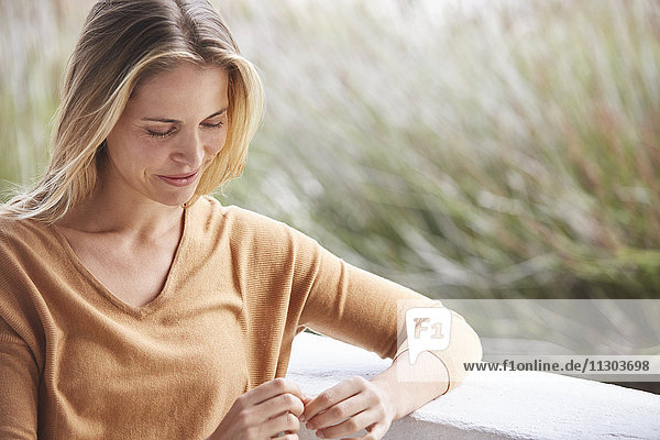 Gelassene blonde Frau auf der Veranda