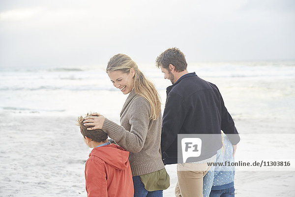 Smiling family walking on winter beach
