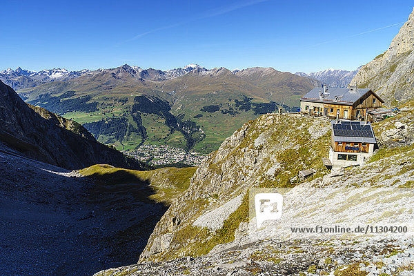 Die Lischana-Hütte SAC (Schweizer Alpen-Club) oberhalb von Scuol im Unterengadin  Schweiz. Blick hinunter zum Dorf Scuol und zu den Silvretta Alpen.