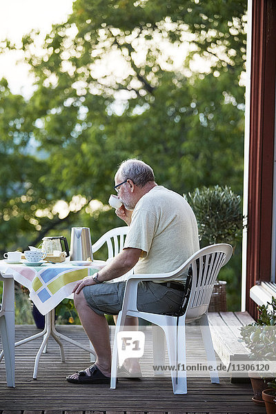 Senior man drinking coffee in garden