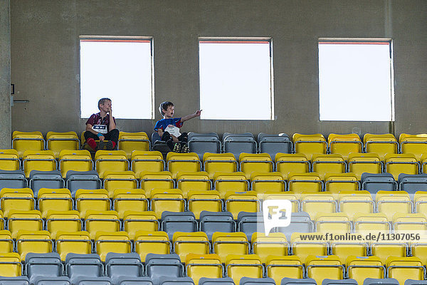 Jungen auf Stadionstühlen