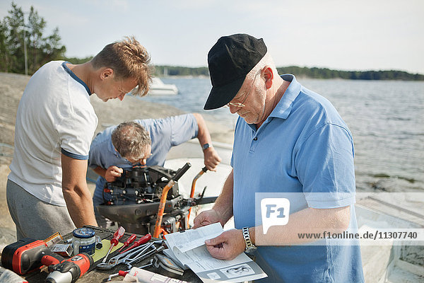 Men repairs boat engine