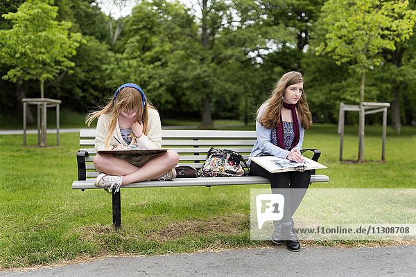 Teenager-Mädchen sitzen auf einer Bank