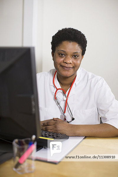 Smiling doctor using computer