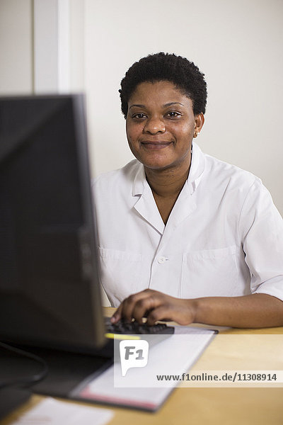Smiling doctor using computer