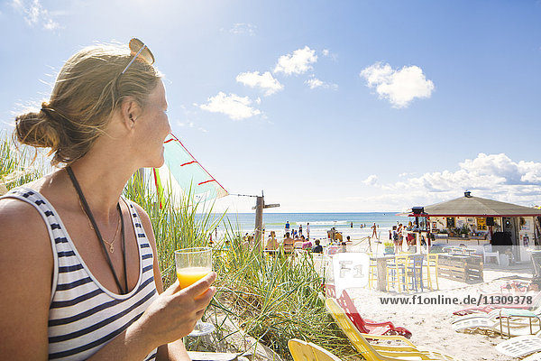 Woman looking at people on beach