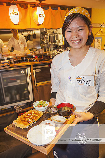 Japan  Honshu  Tokio  Restaurant Kellnerin serviert Essen