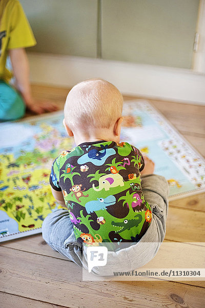 Baby boy looking at map