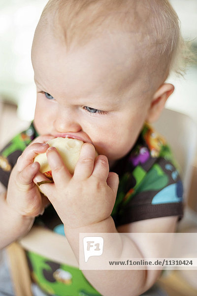 Baby boy eating apple