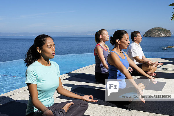 Yogagruppe beim Training am Meer