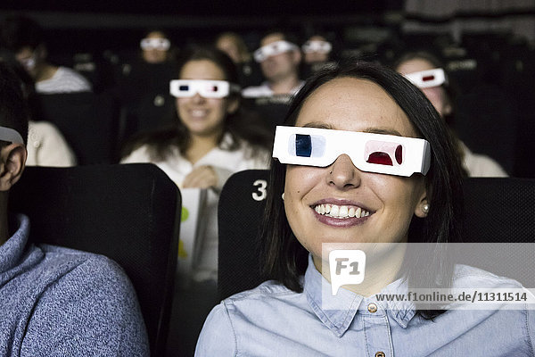 Frau mit 3D-Brille beim Betrachten eines Films im Kino