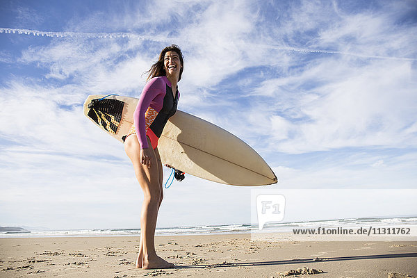 Happy woman with surfboard on the beach